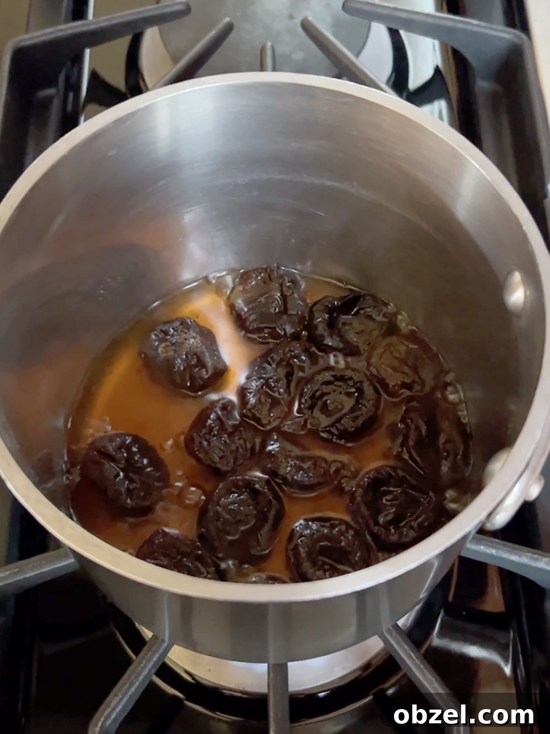 How to Make Lekvar Prune Butter at Home 5 Prunes simmering in a pot.