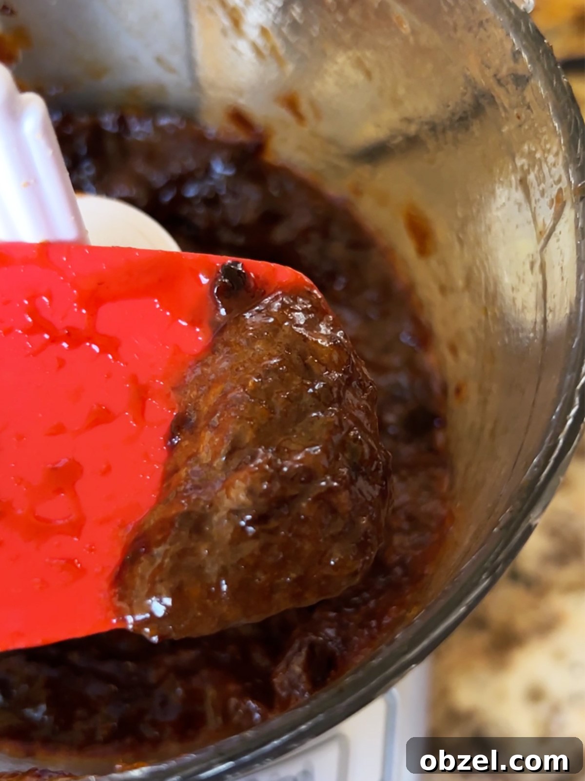 How to Make Lekvar Prune Butter at Home 10 Prune filling after being chopped, shown close up on a red spatula.