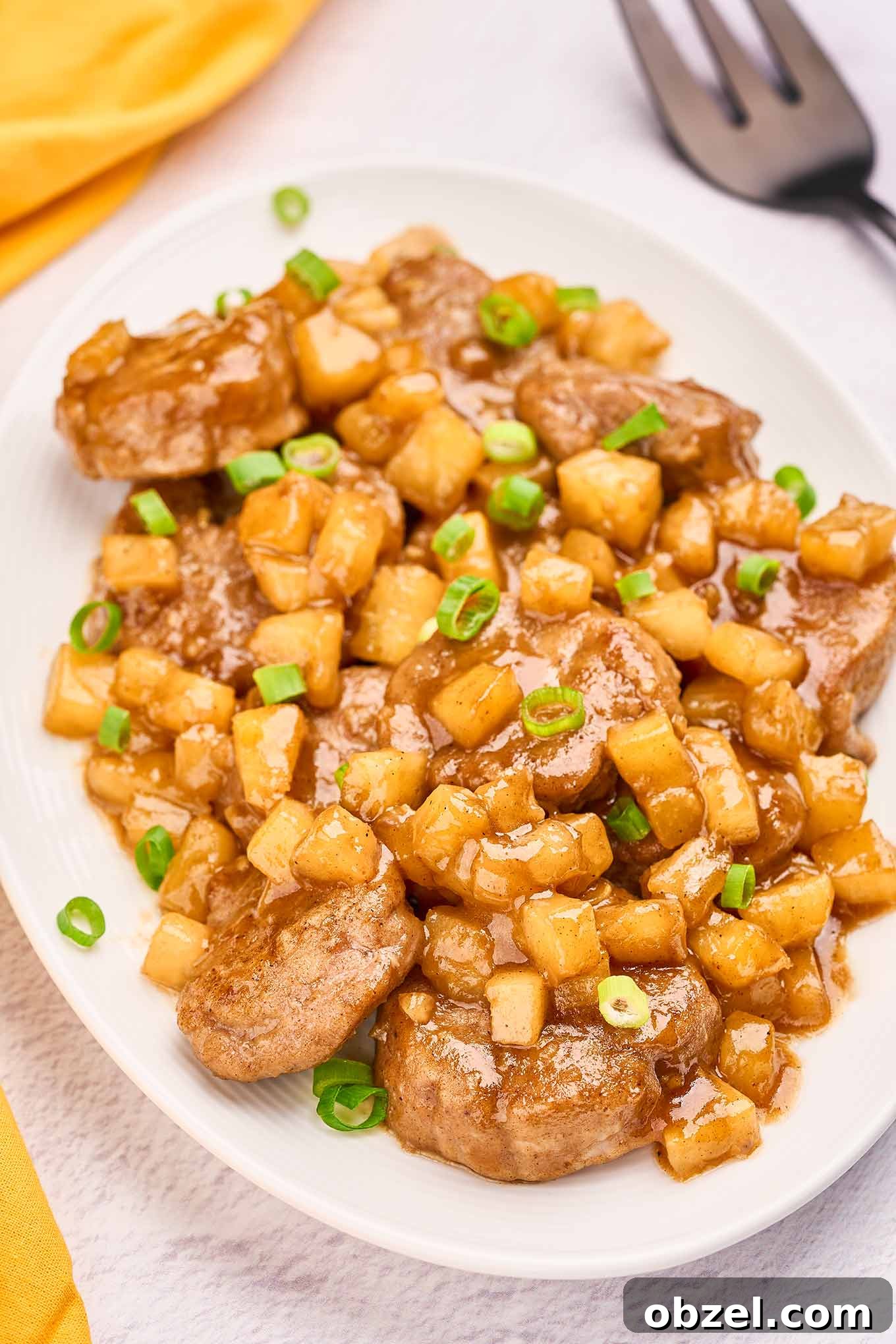Caribbean Pineapple Pork Skillet with Bell Peppers 5 Pork medallions coated in pineapple rum sauce and garnished with sliced scallions for a Caribbean-inspired pineapple pork dinner.