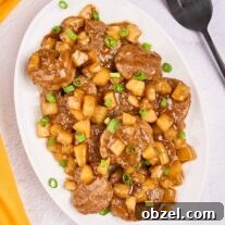Caribbean Pineapple Pork Skillet with Bell Peppers 6 An oval serving platter of Caribbean-style pineapple pork with tender pork medallions, pineapple chunks, and scallions in a sweet-savory rum sauce.