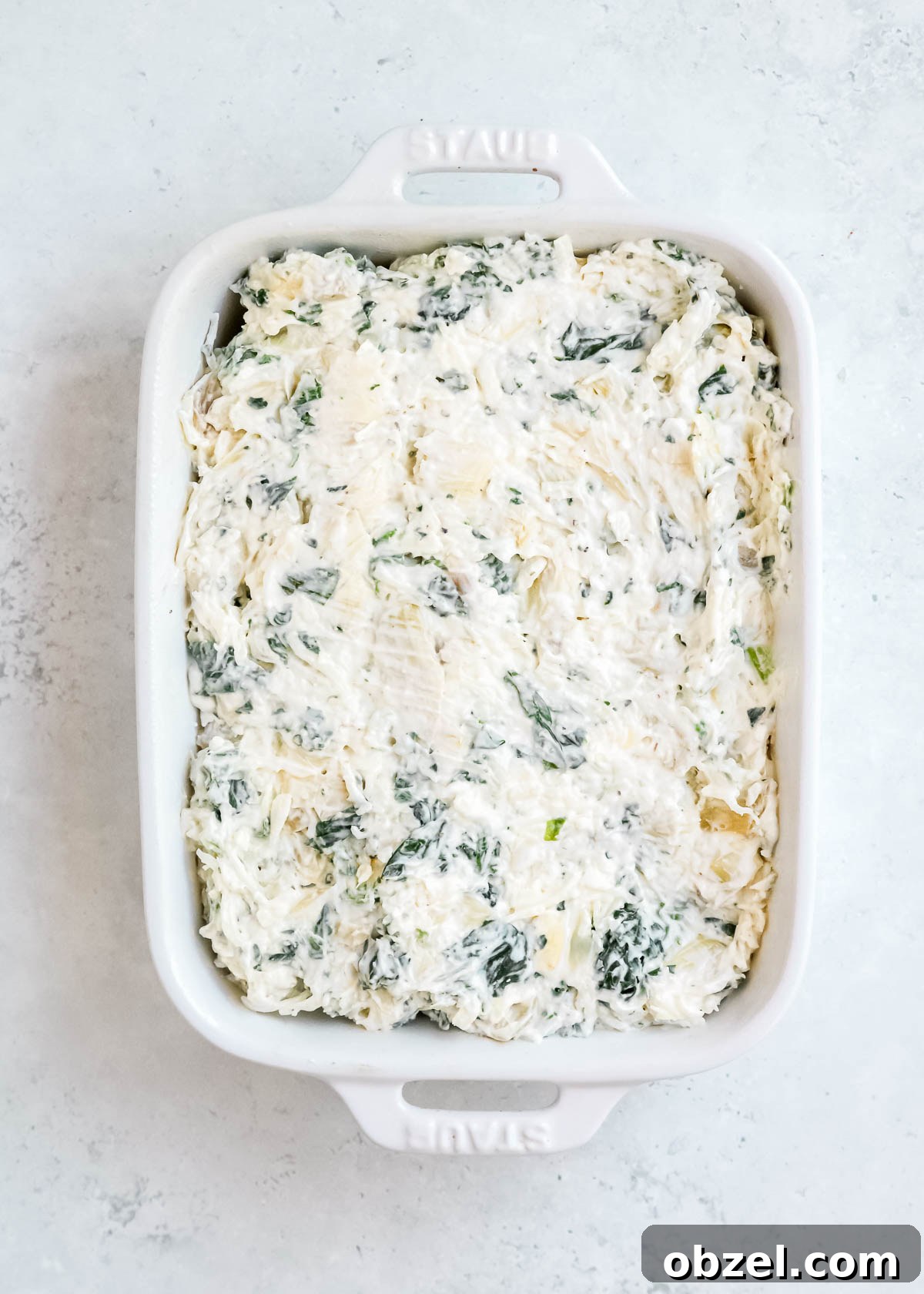 Creamy Spinach Artichoke Dip Recipe 8 spinach dip spread in a white baking dish