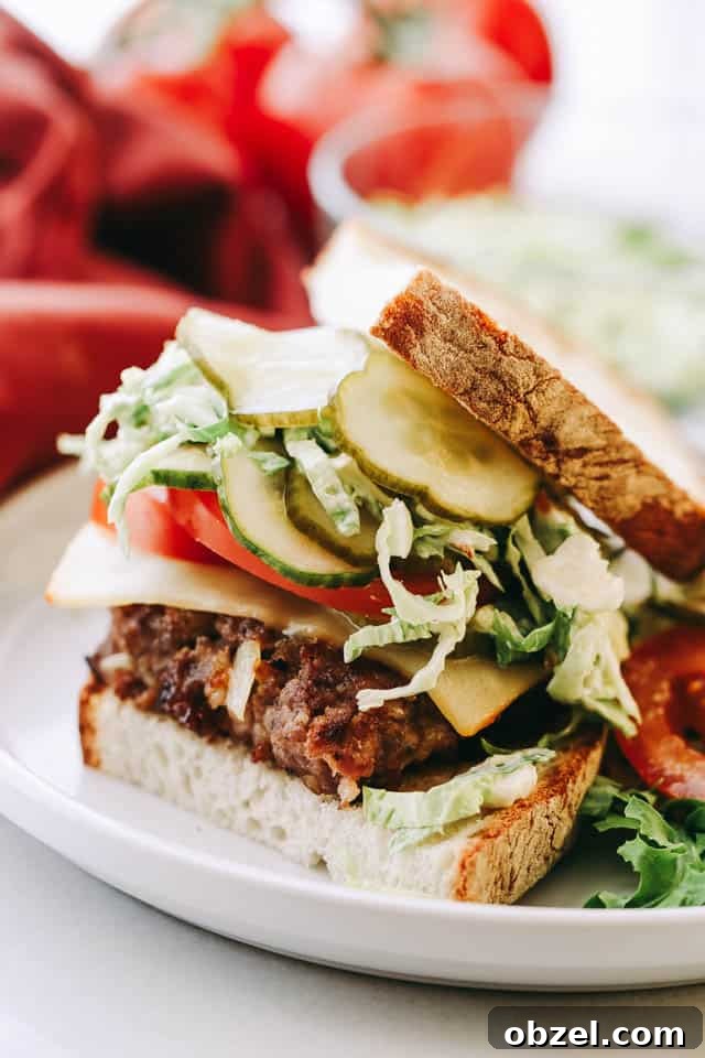 Sausage Smashed Burgers topped with pickles and cheese.
