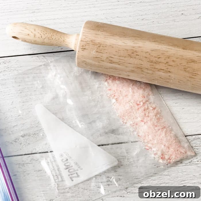 DIY Peppermint Candy Cane Lip Scrub for Soft Lips 6 rolling pin breaking candy canes inside ziploc bag into tiny pieces for use in peppermint candy cane lip scrub with essential oils
