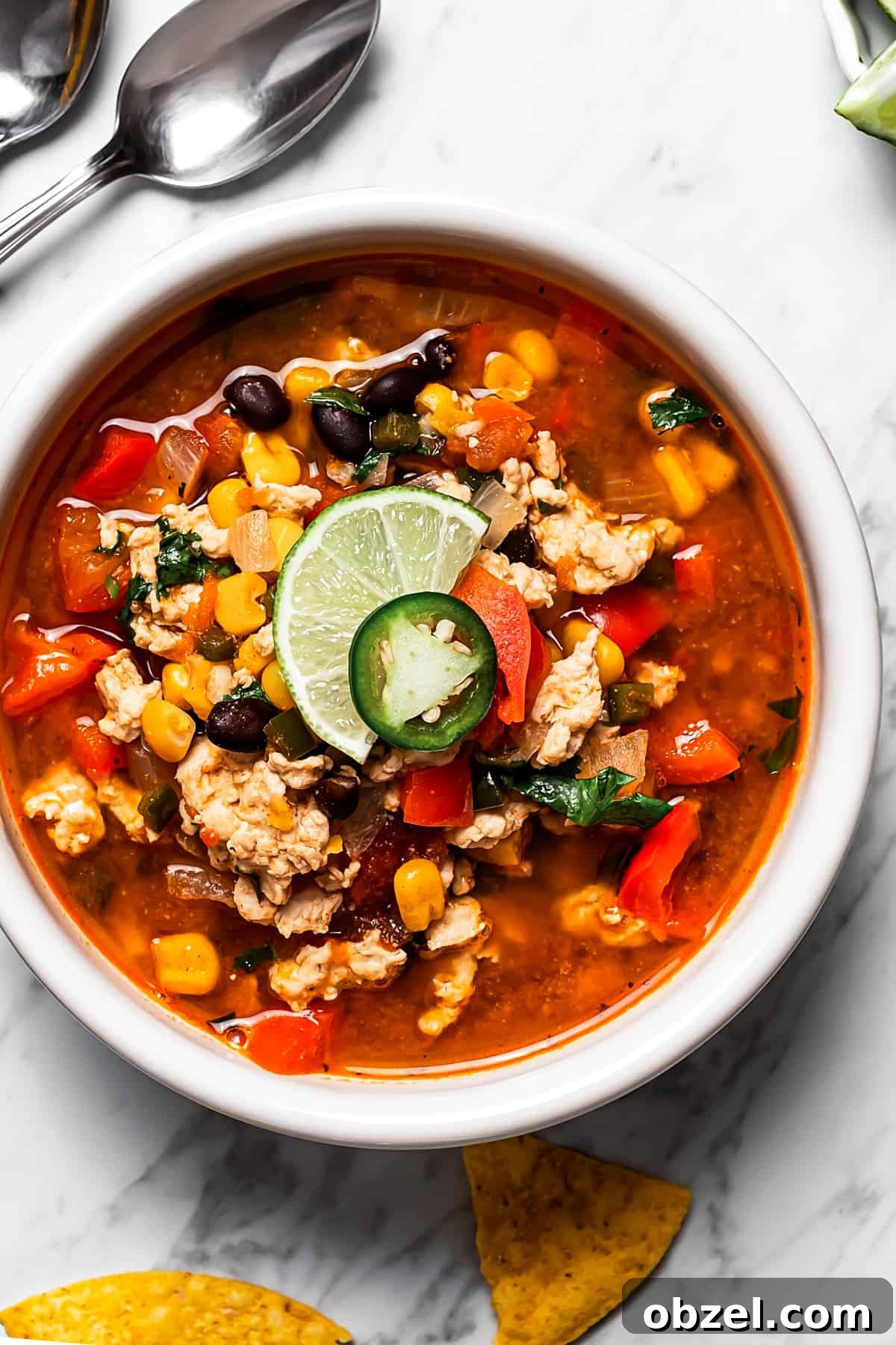 Easy taco soup in a bowl with a lime wedge, jalapeño, and cilantro on top.