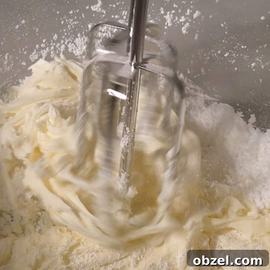 Lemon Blueberry Cake with Mascarpone Frosting 12 Electric mixer blending mascarpone cheese and powdered sugar for frosting.