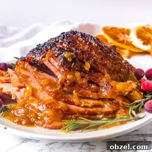 Pressure cooker ham sliced on a plate with cranberries and rosemary.