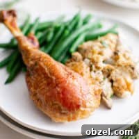 Roast turkey leg with green beans on a plate.