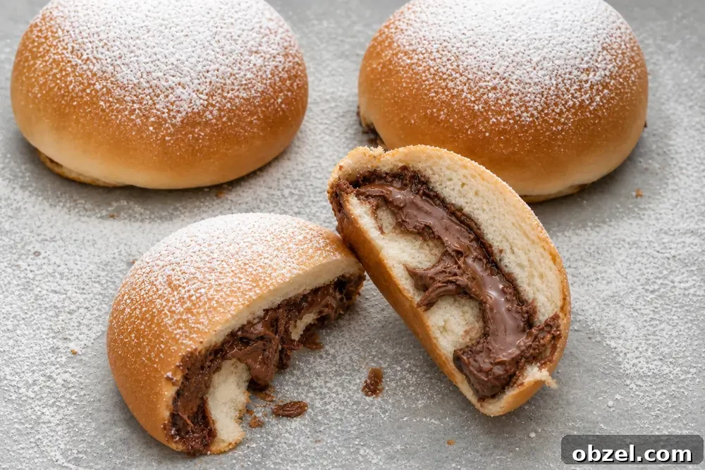 Golden baked buns filled with melted chocolate hazelnut spread and dusted with icing sugar.
