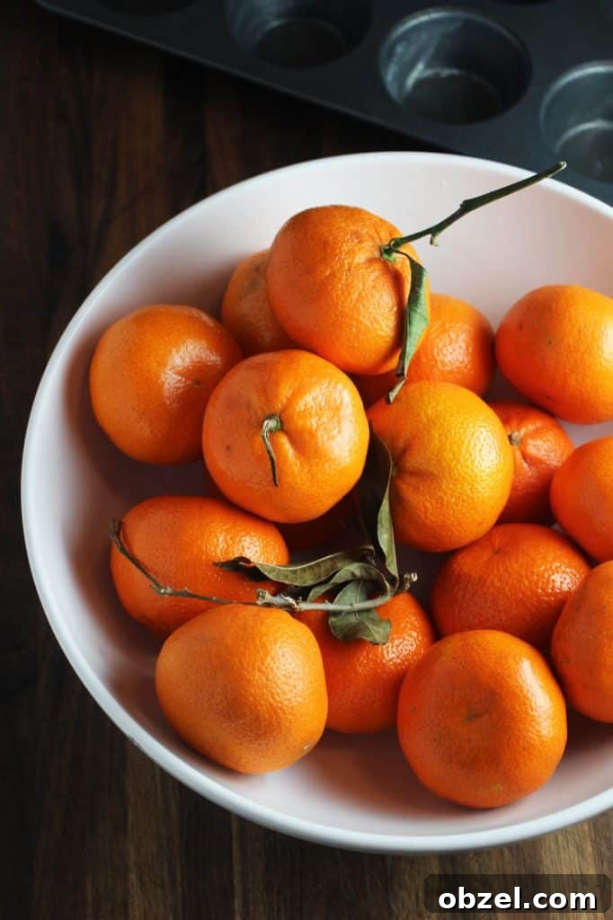 Mandarin Orange Greek Yogurt Muffins 3 Mandarin oranges with leaves in a white fruit bowl