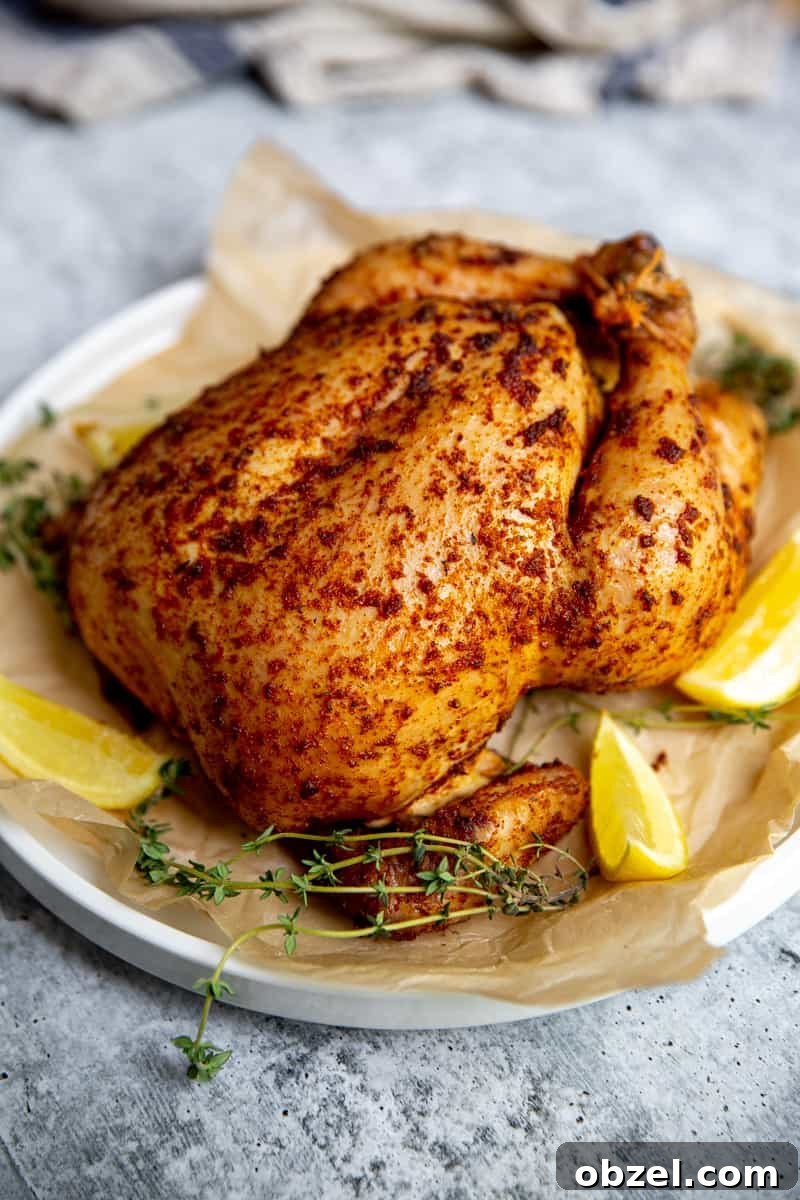 Traeger Smoked Whole Chicken Recipe 2 Close up of a Traeger smoked chicken on a serving platter.