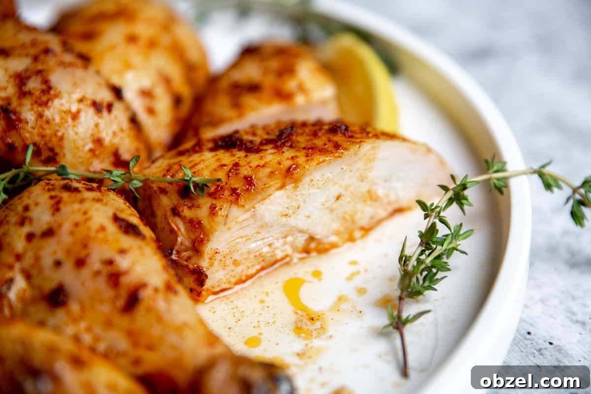 Traeger Smoked Whole Chicken Recipe 10 Smoked Chicken on a plate with lemon slices and garnishes.