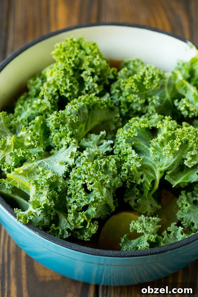 Zuppa Toscana Soup Recipe with Sausage and Kale 7 Fresh kale leaves going into a pot of soup.