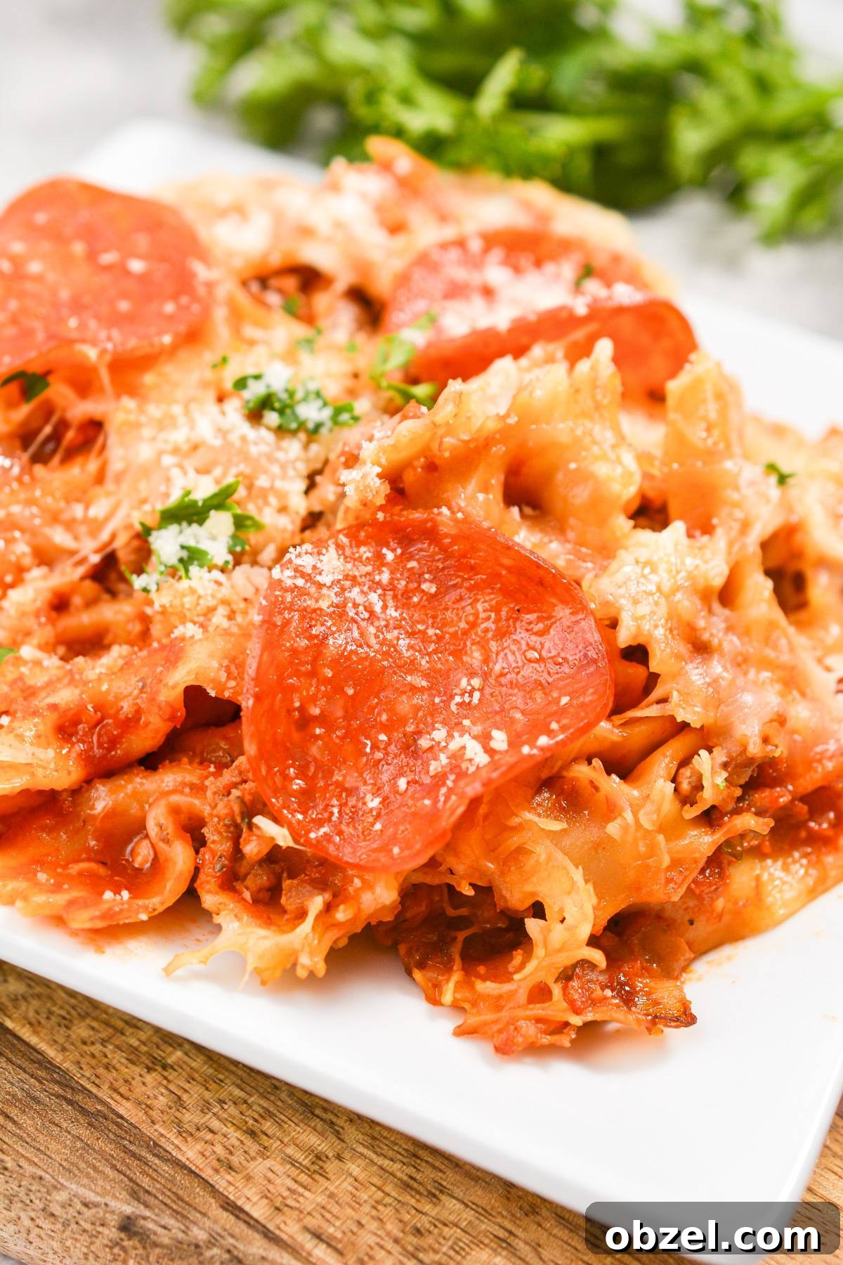 Crock Pot Pizza Casserole with Pasta and Pepperoni 6 A close up of a pizza casserole, topped with pepperoni and garnished with parsley.
