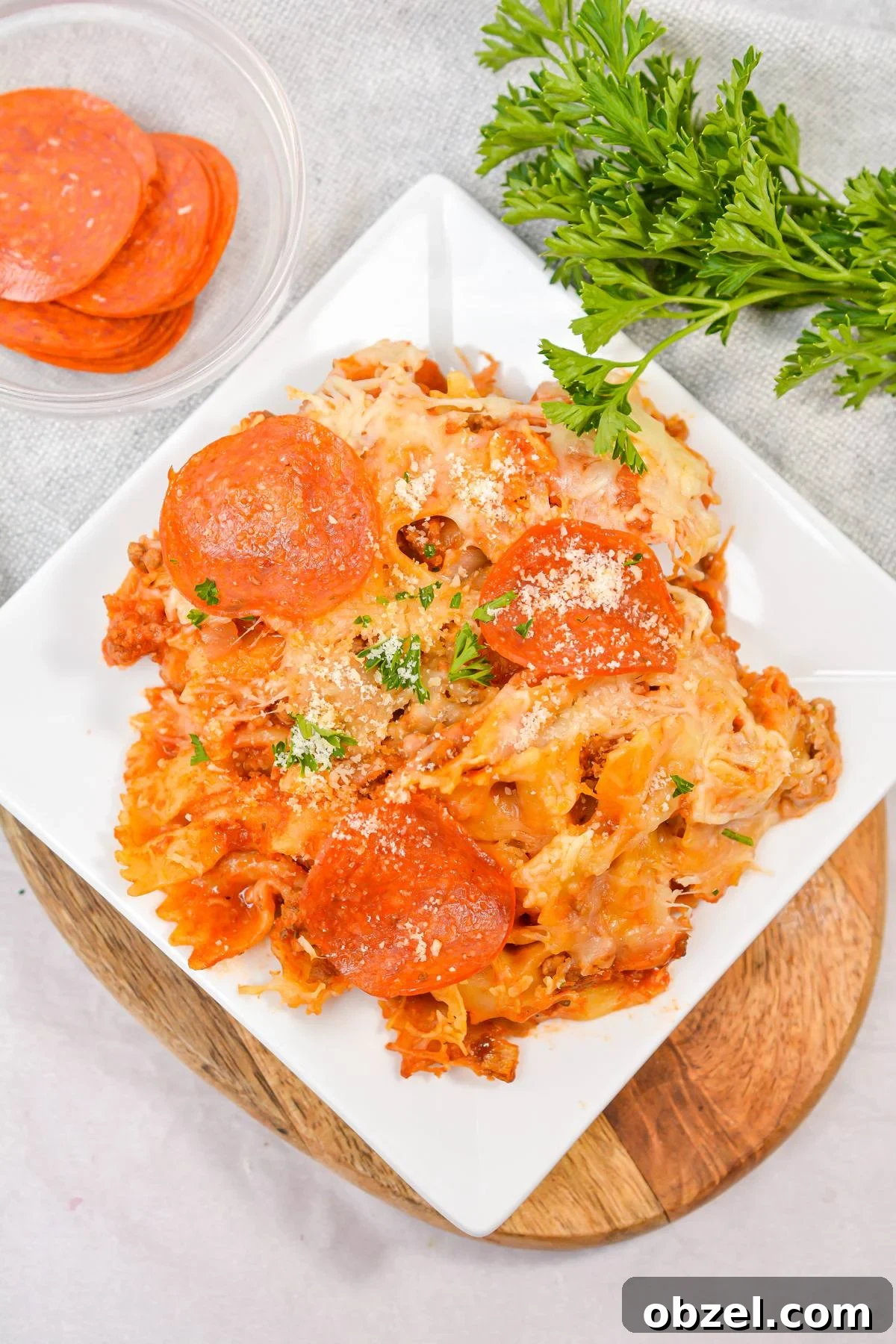 Crock Pot Pizza Casserole with Pasta and Pepperoni 7 An overhead shot of a plate of pizza casserole, topped with pepperoni.