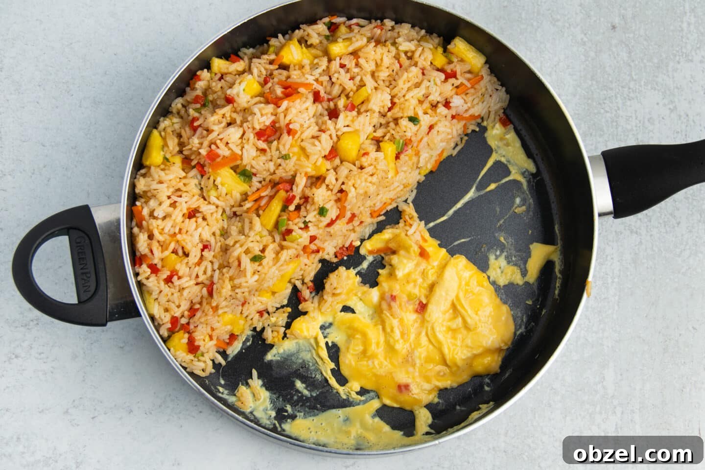 Pineapple Shrimp Fried Rice Recipe 11 Fried rice pushed to one side of the skillet with scrambled eggs cooking on the other side.