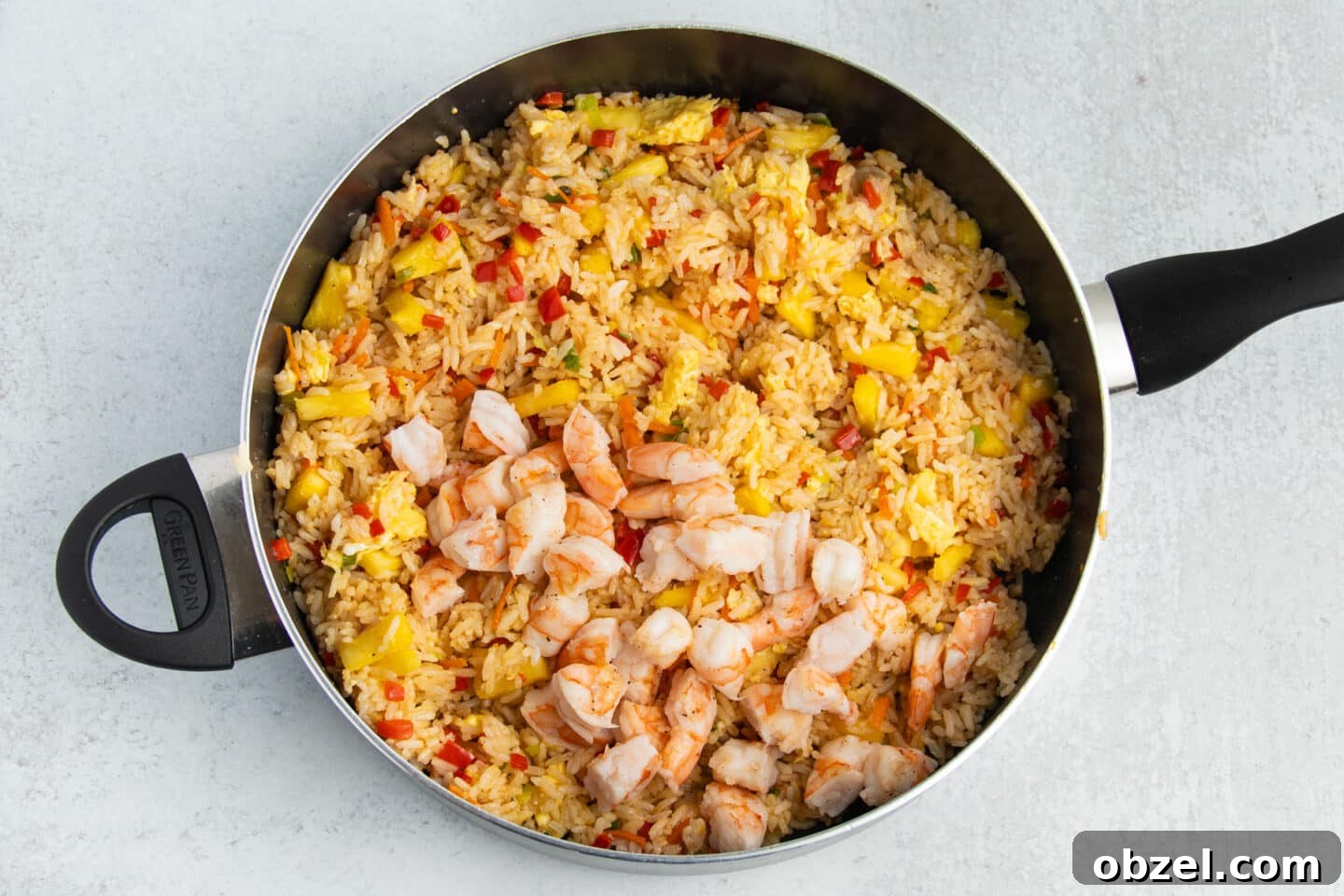 Pineapple Shrimp Fried Rice Recipe 12 Shrimp added back into fried rice in a skillet.