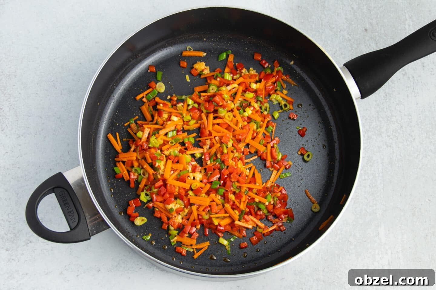Pineapple Shrimp Fried Rice Recipe 8 Bell pepper, carrots, green onions, ginger, and garlic cooking in a skillet.