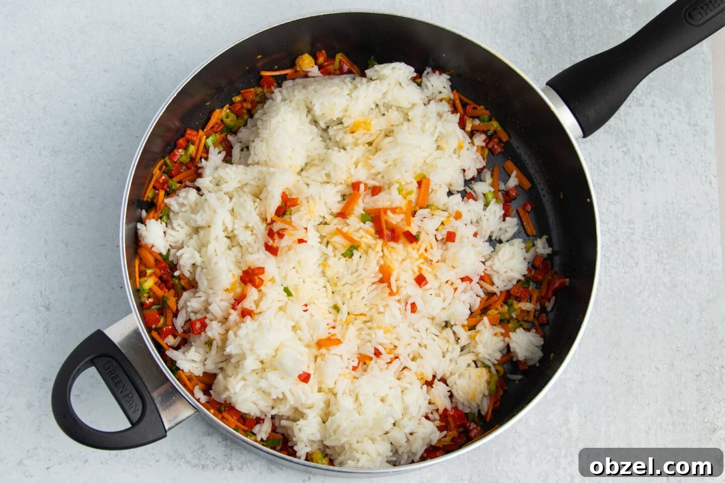 Pineapple Shrimp Fried Rice Recipe 9 Cooked rice added to vegetables in a skillet.
