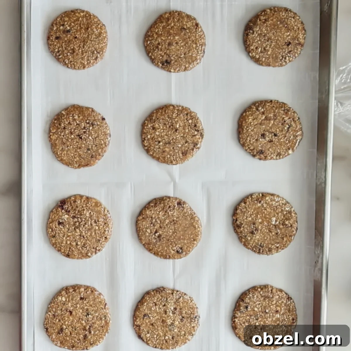 flattened cookie dough circles on parchment-lined baking sheet.