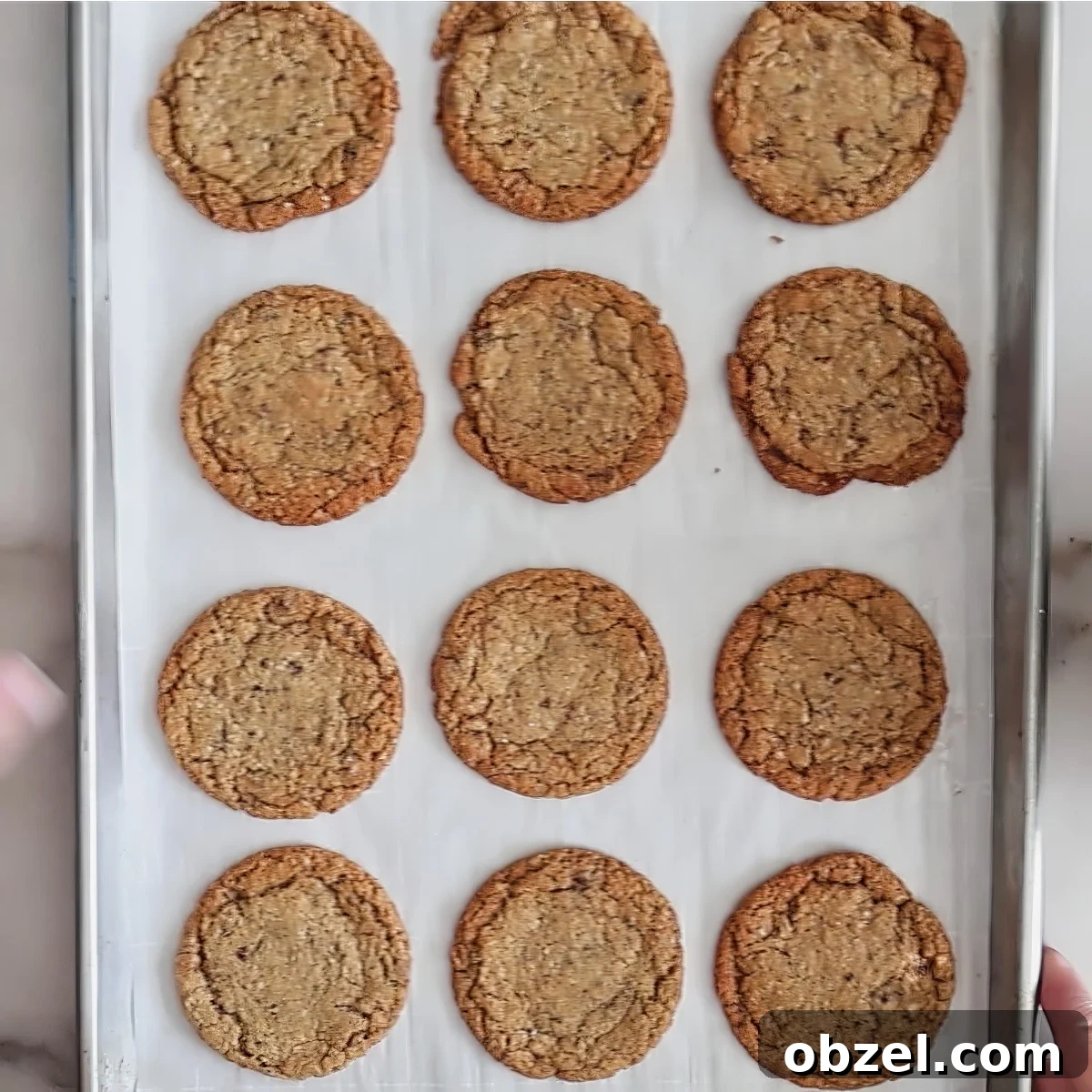 baked oatmeal cookies on parchment-lined baking sheet.