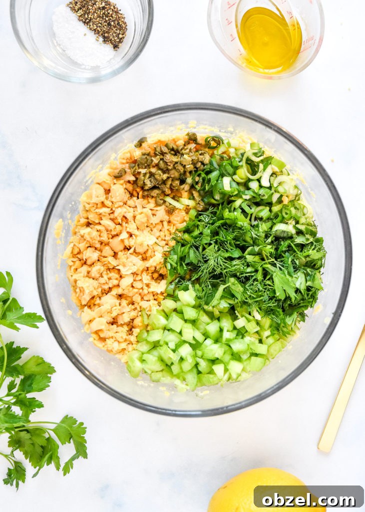 Lemony Herbed Mashed Chickpea Salad Recipe 8 ingredients for the herby lemon mashed chickpea salad all chopped in a glass bowl.
