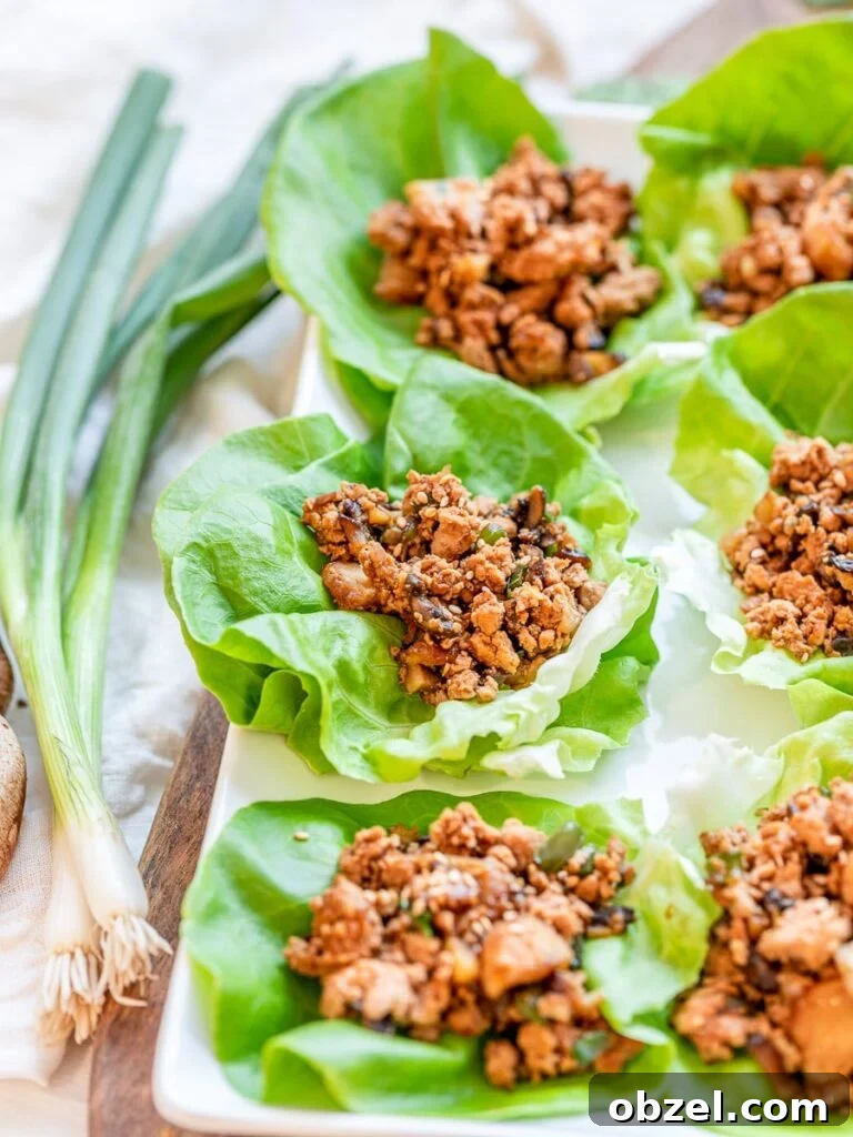 PF Chang's inspired chicken lettuce wraps on a wooden board with scallion