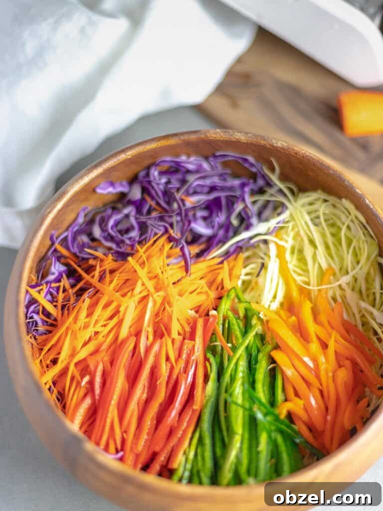rainbow cabbage salad in wooden bowl next to cutting board