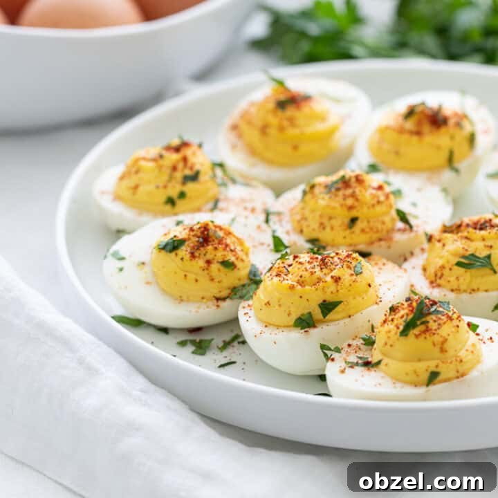 classic keto deviled eggs with parsley and paprika on a white plate