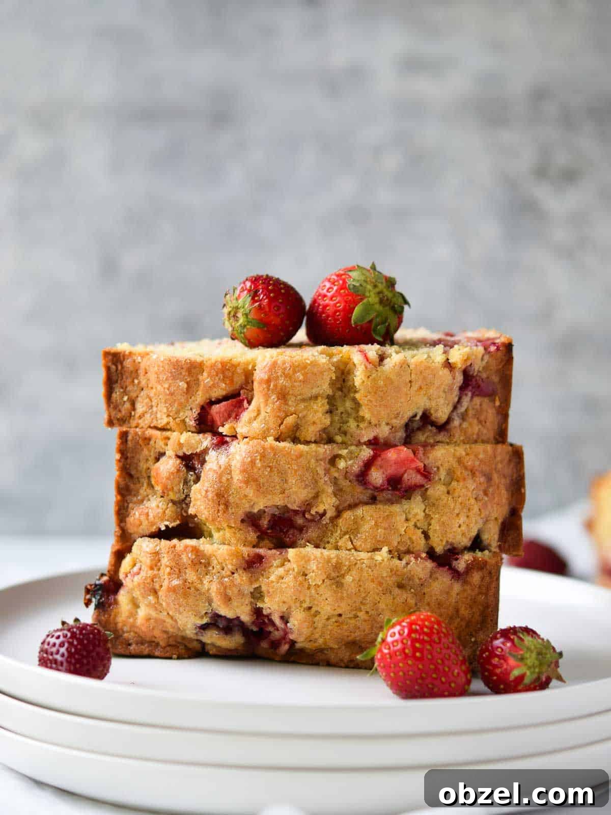 Fresh Buttermilk Strawberry Bread Recipe 2 Strawberry bread sliced and stacked on a white plate.