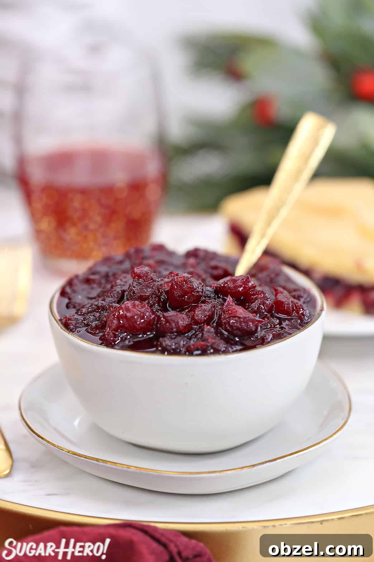 Cranberry Orange Sauce Recipe 4 Homemade cranberry sauce in a white bowl with a piece of cranberry cake behind.