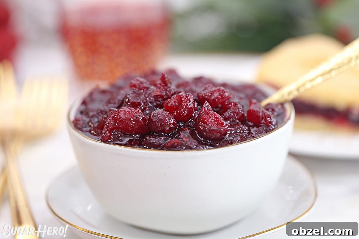 Cranberry Orange Sauce Recipe 5 Homemade cranberry sauce in a white bowl with a gold spoon.