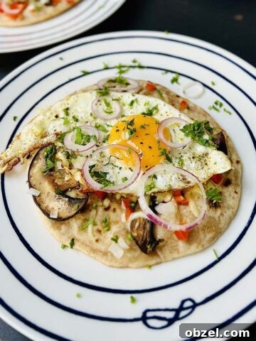 Egg on tortilla ready to be served and sprinkled with fresh herbs and some red onion rings.