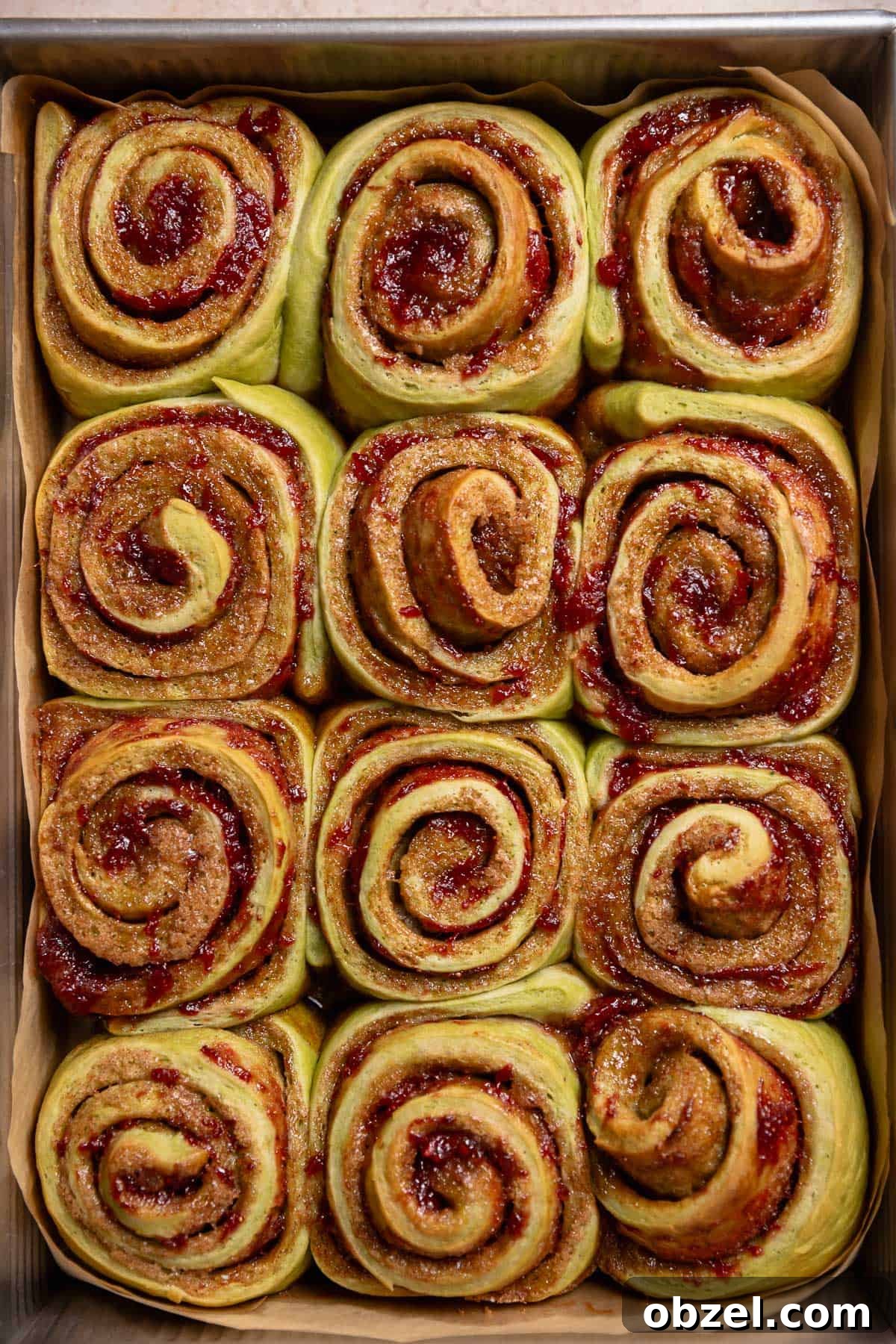 Strawberry Matcha Cinnamon Rolls Recipe 11 Baked cinnamon rolls in a pan.