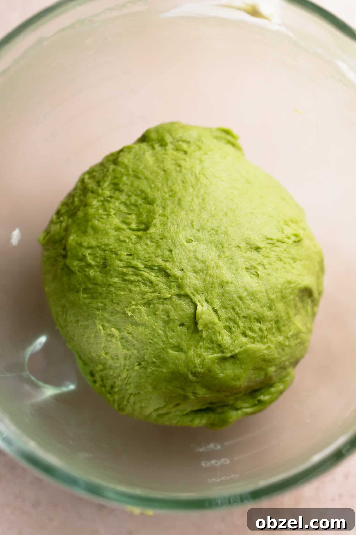 Strawberry Matcha Cinnamon Rolls Recipe 7 Matcha dough ball in a glass mixing bowl resting.