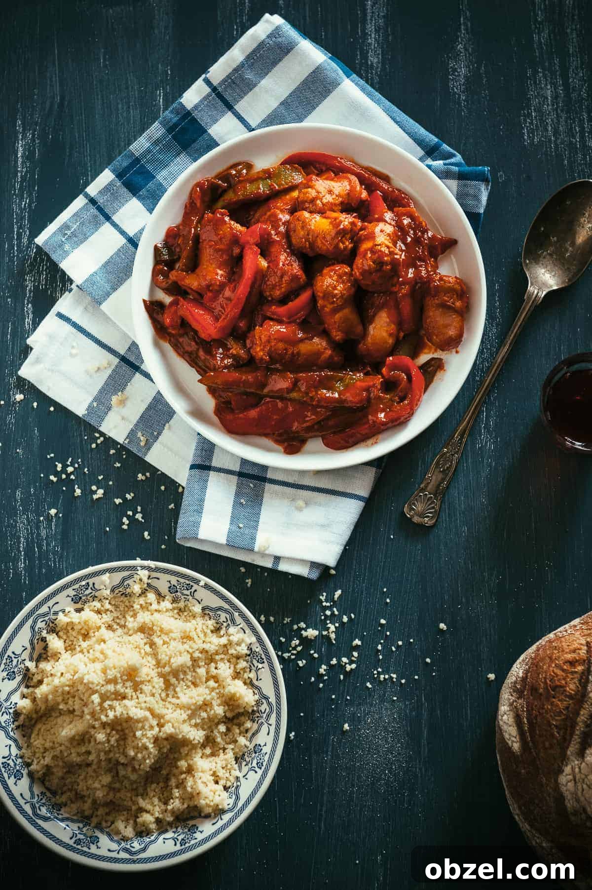 a top down view of a plate filled with sausages and peppers cooked in a tomato sauce