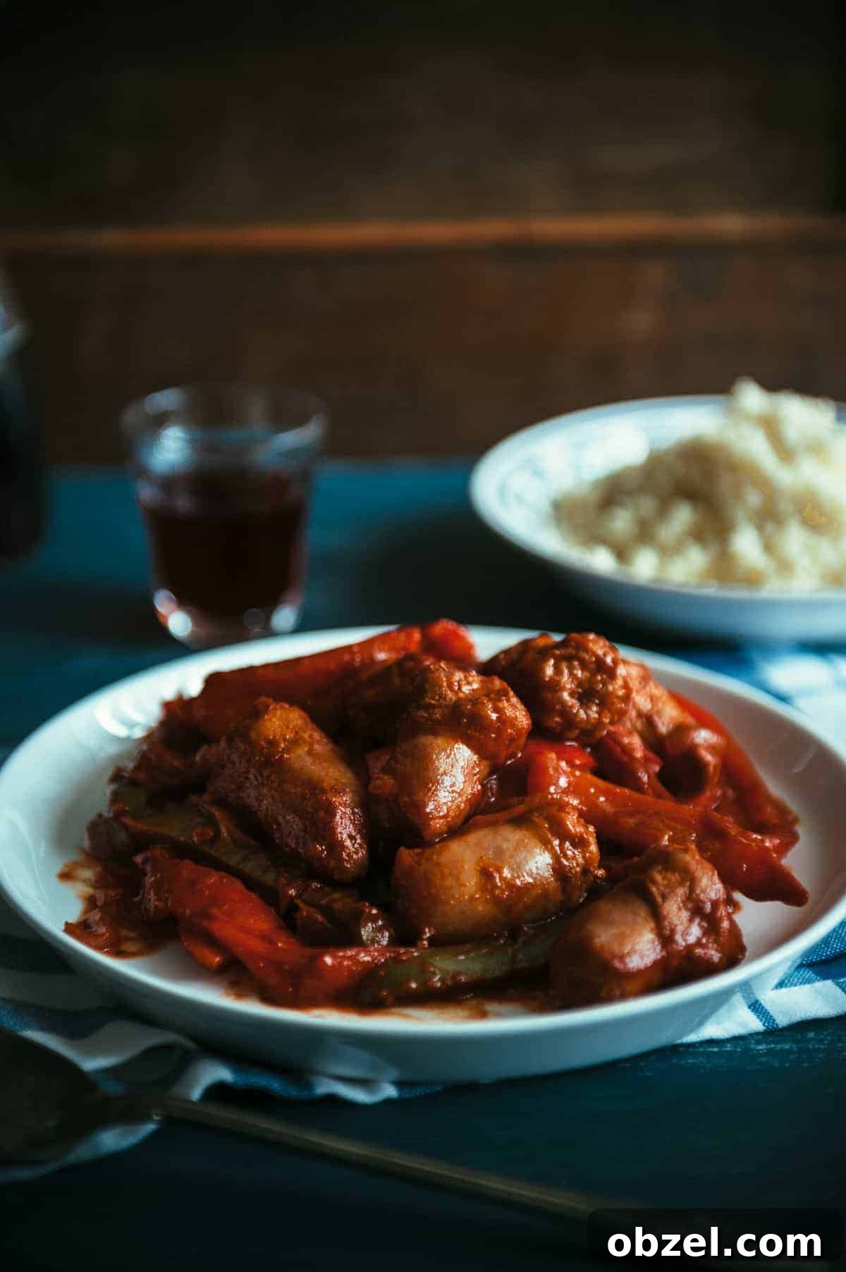a plate filled with sausages and peppers cooked in a tomato sauce
