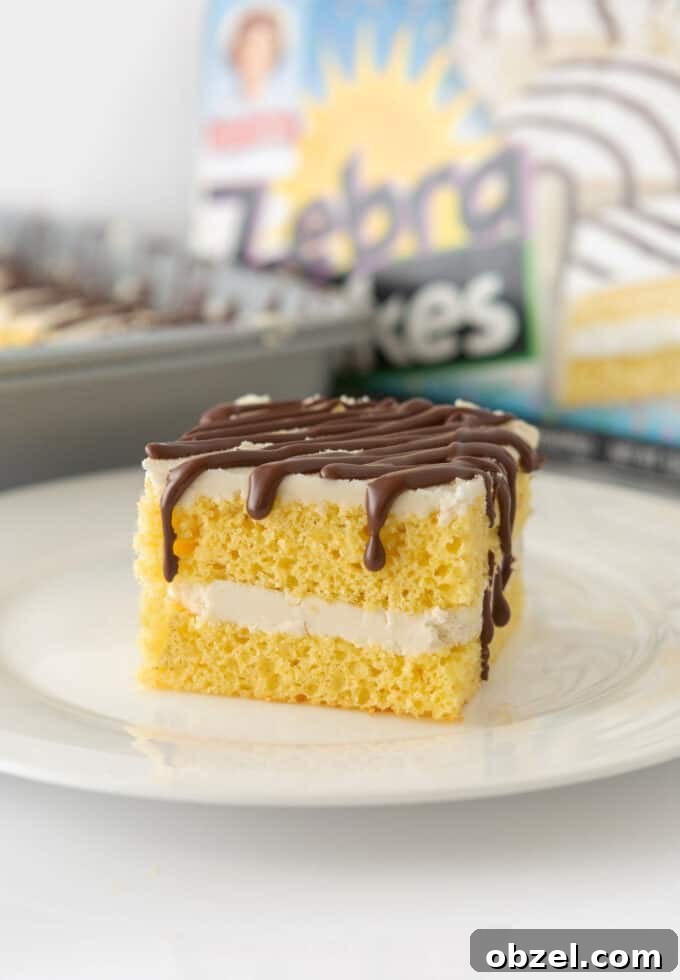 9x13-Inch Zebra Cake Recipe 9 Square of homemade zebra cake on plate with box of Little Debbie zebra cakes in background