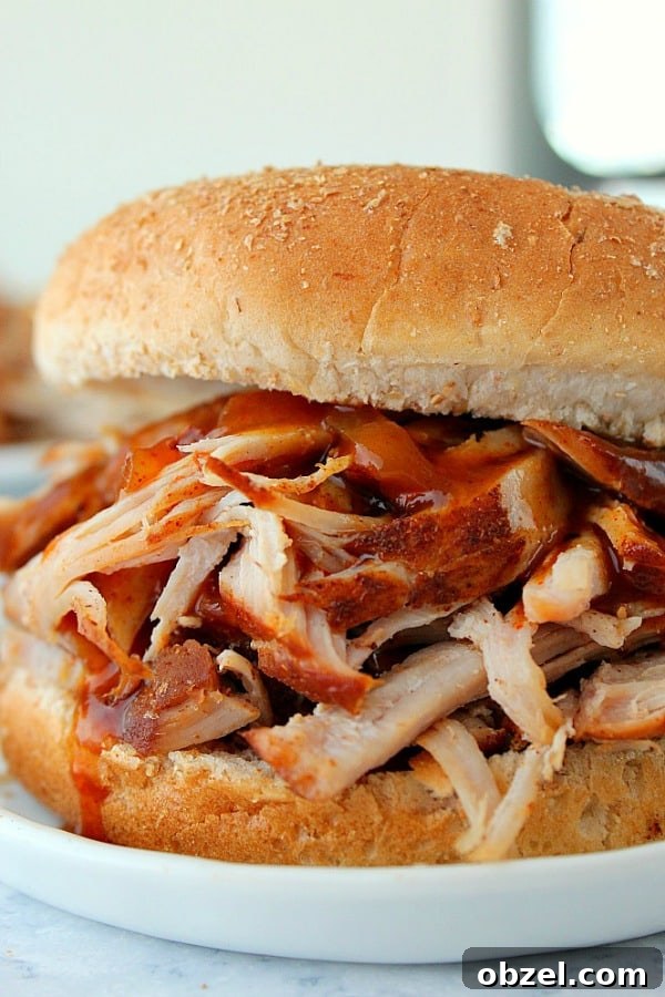 14-Day Instant Pot Meal Plan with Recipes and Grocery List 11 Instant Pot Pulled Pork in a bun on white plate.