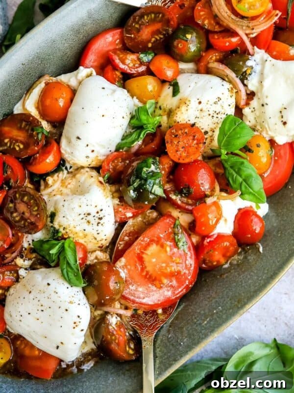 Deviled Egg Potato Salad Recipe 9 Green serving dish with tomatoes, burrata and basil. Lots of dressing and seasoning, up close
