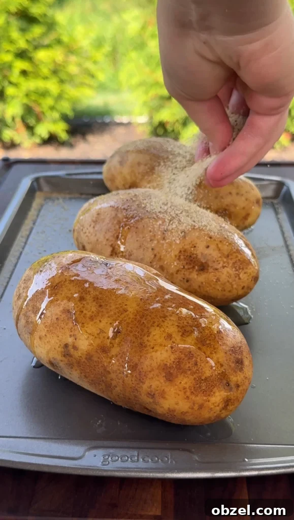Loaded Baked Potatoes with Grilled Steak Bites 6 foil wrapped potatoes cooking on the grill