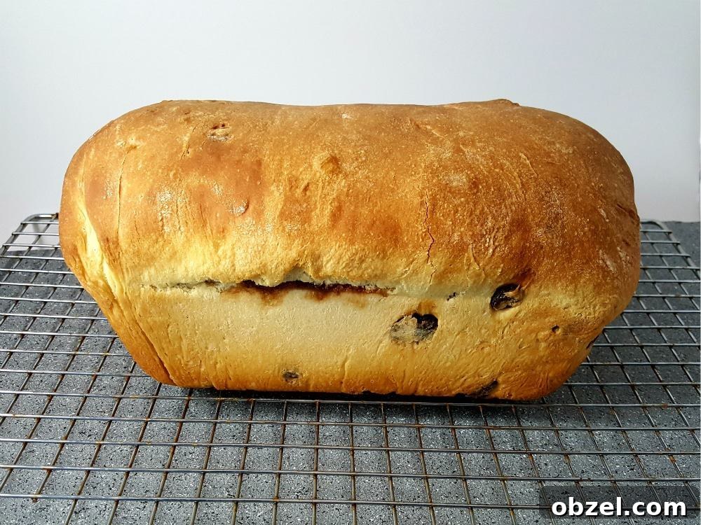 Cinnamon Raisin Swirl Bread Recipe 9 A baked loaf of easy cinnamon swirl bread on a wire rack.