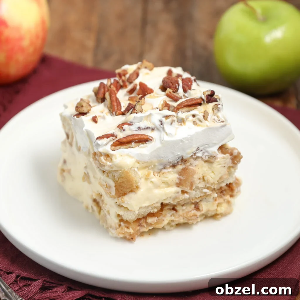 Caramel Apple Tiramisu Recipe: Autumn Dessert Twist 2 A slice of creamy caramel apple tiramisu topped with whipped cream and chopped pecans sits on a white plate, with a red napkin and apples in the background.