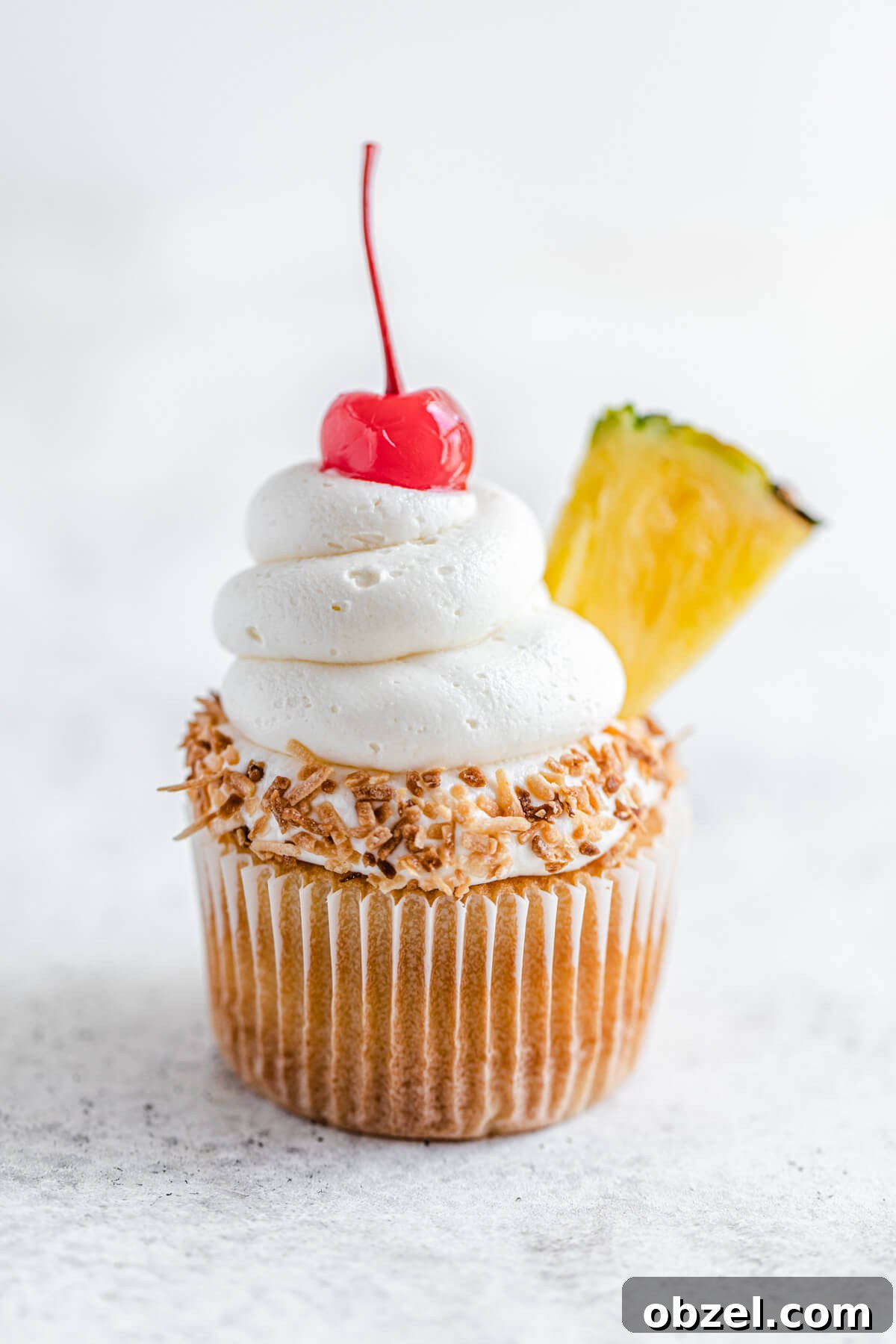 Pina Colada Cupcakes with Rum Infused Coconut Frosting 4 one cupcake dipped in coconut and topped with a cherry and pineapple