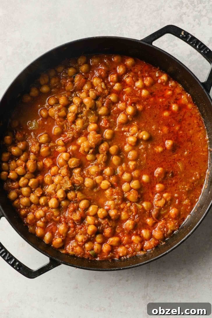 cooked chickpea curry in  a black skillet