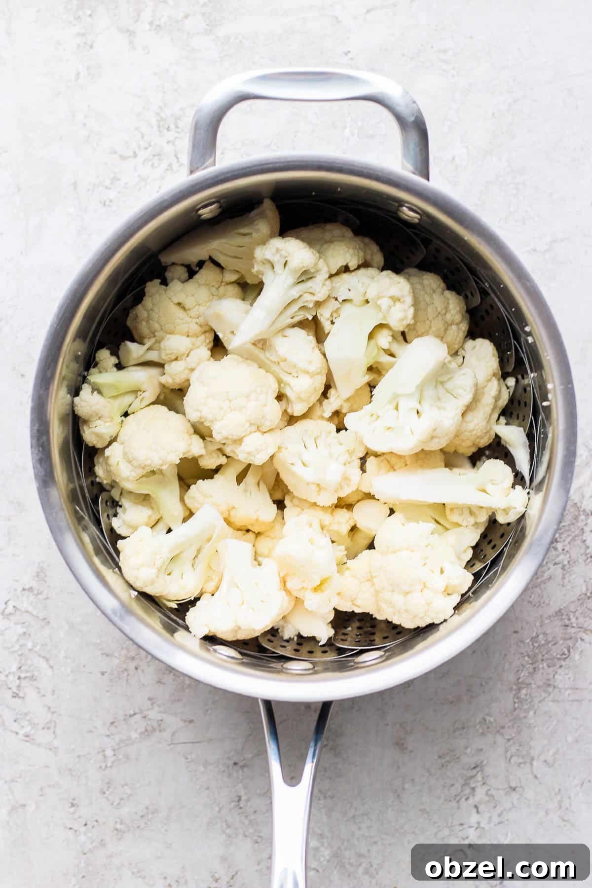 Fresh cauliflower florets in a steamer basket.