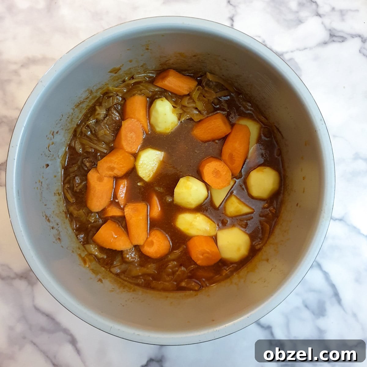 South African Beef Bredie Stew Recipe 11 Raw potatoes and carrots being added to the beef bredie.