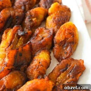 Crispy Fried Maduros (Sweet Plantains Recipe) 9 Golden brown fried plantains with crispy edges on a plate.