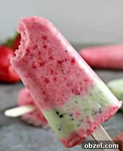 A red and green popsicle with a bite taken out of the top.