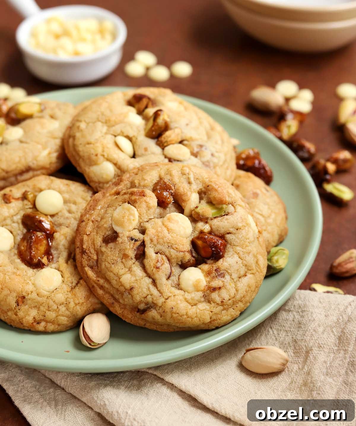 Brown Butter Pistachio White Chocolate Cookies 3 side view of caramelized pistachio brown butter white chocolate cookies on a plate