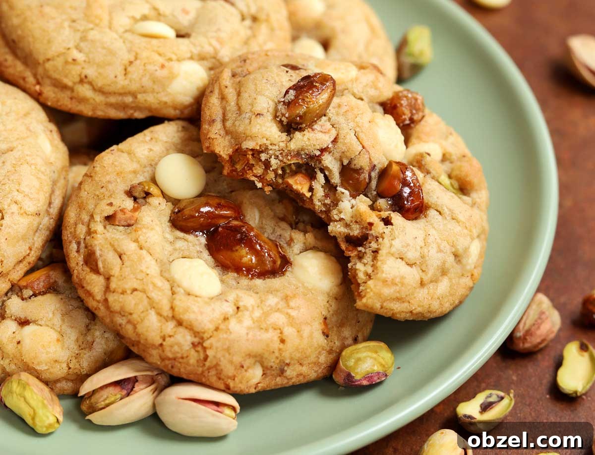 Brown Butter Pistachio White Chocolate Cookies 7 side view of caramelized pistachio brown butter white chocolate cookies on a plate with bite